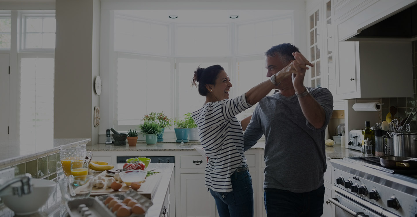 Couple dancing in kitchen for spine health