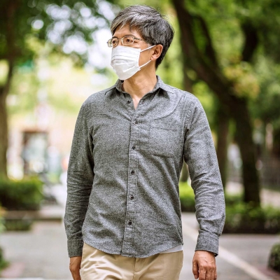 Man walking outdoors while wearing a mask.